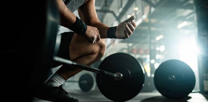 low-angle-view-unrecognizable-muscular-build-man-preparing-lifting-barbell-health-club-2